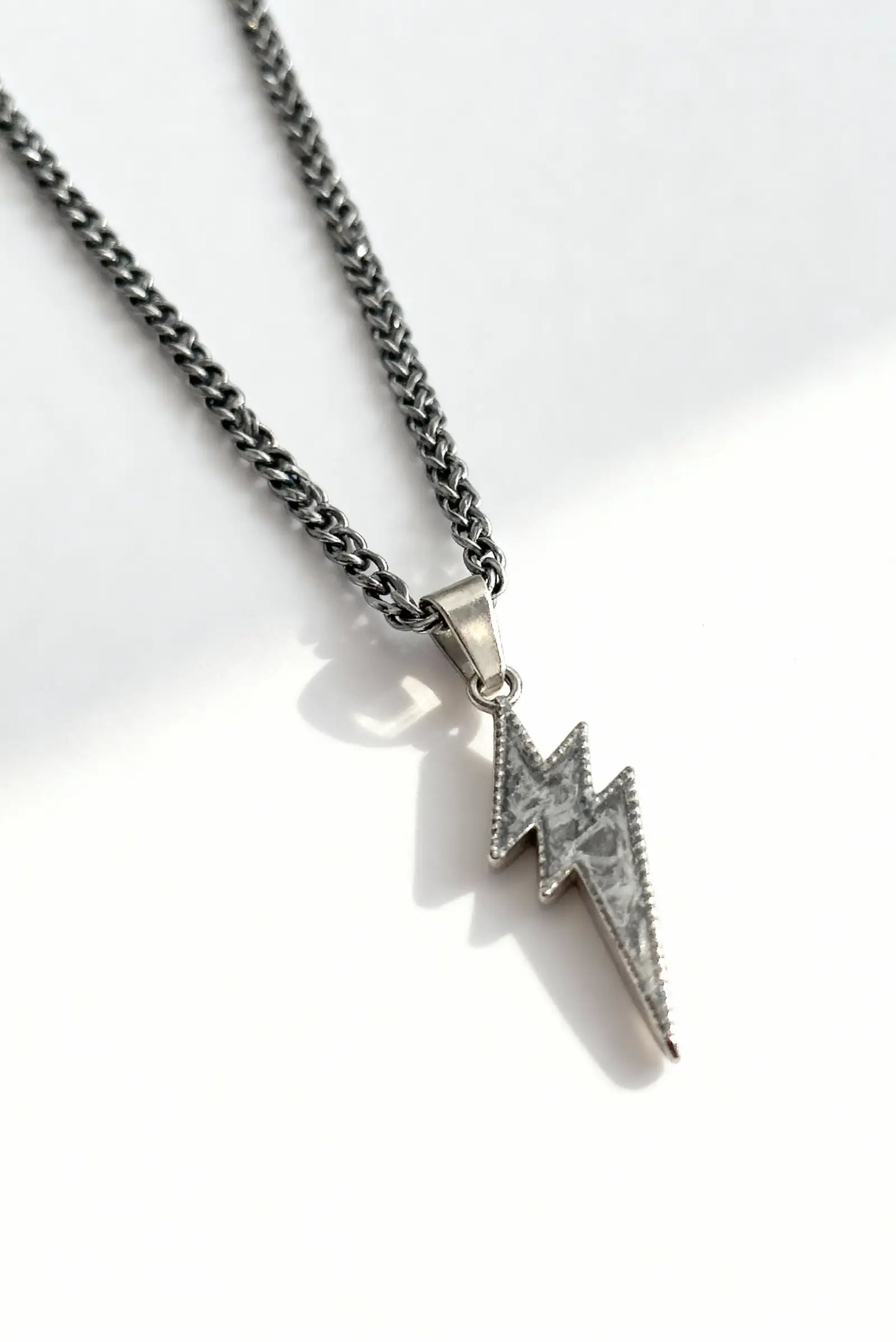 Collar unisex de plata con dije de rayo DOPAMYN, joyería minimalista moderna.