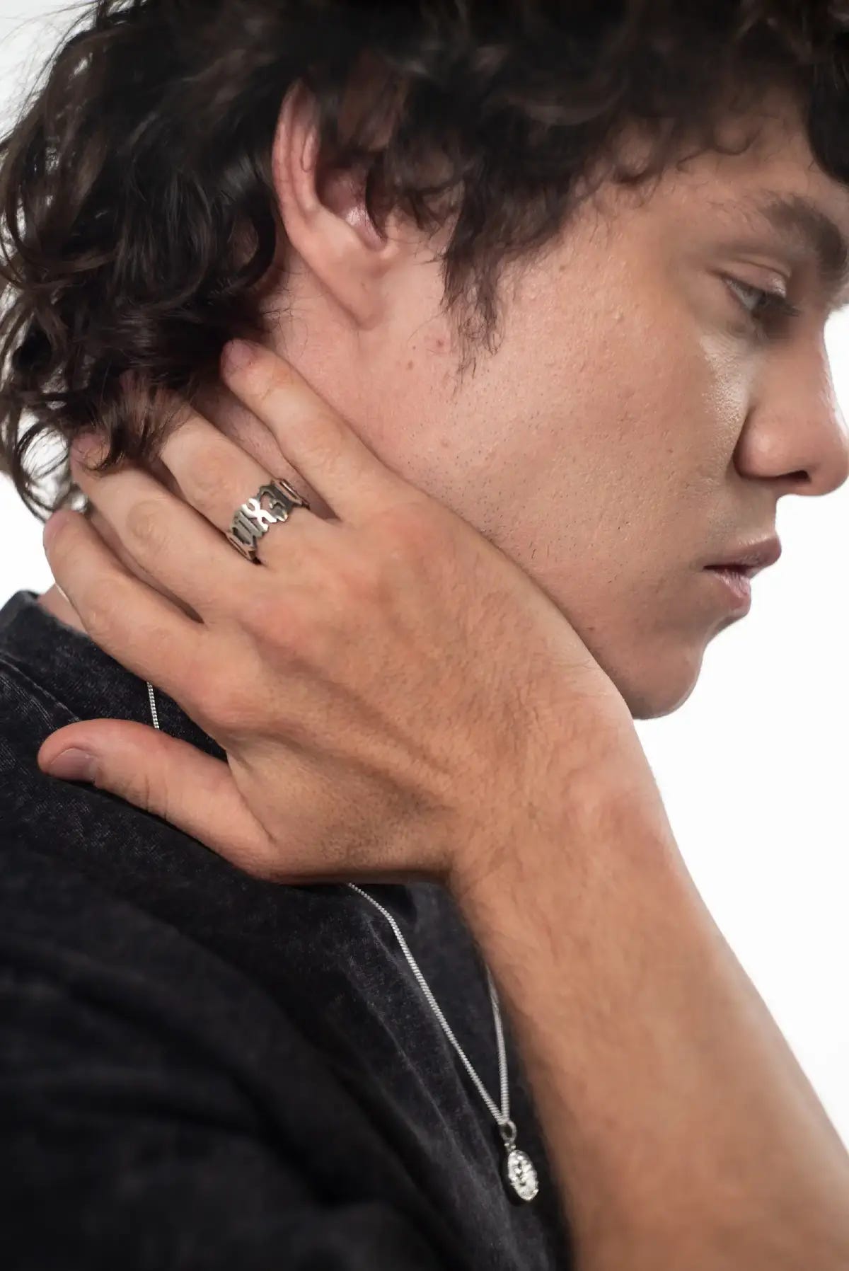 Anillo México en la mano de un hombre, detalle del diseño calado en plata .950