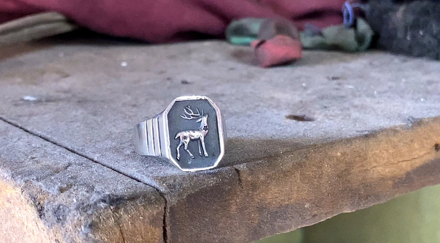 Anillo Deer Signet terminado sobre la mesa de trabajo del taller DPMN★